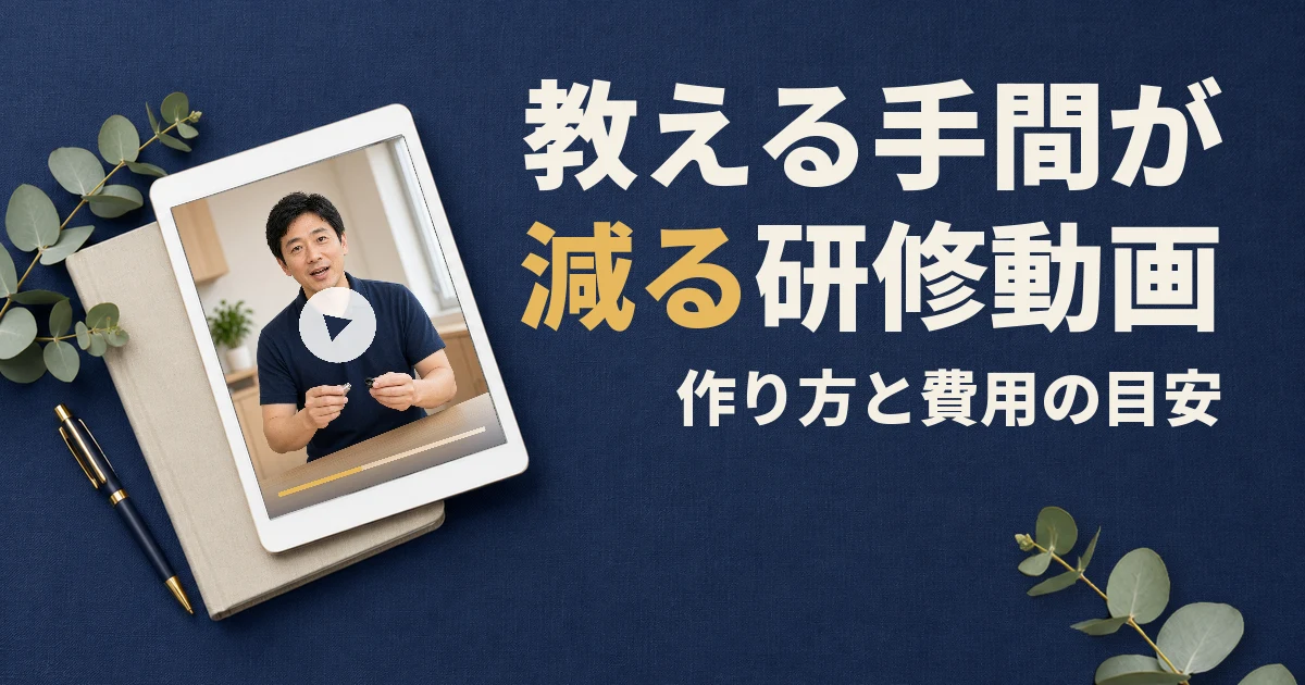 教える手間が減る研修動画。作り方と費用の目安。紺色の机の上に、講師が手元を見せながら説明する研修動画を映したタブレットとノート、ペン、ユーカリの葉がある