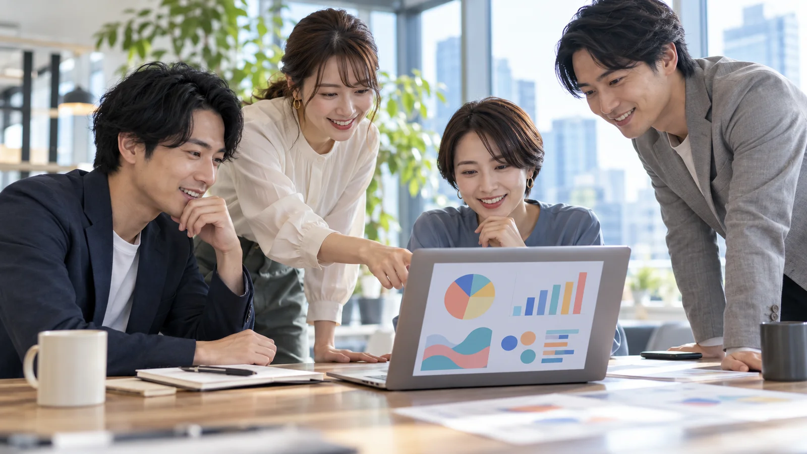 ノートパソコンのグラフを見ながらSNSの数字を確認しているチーム