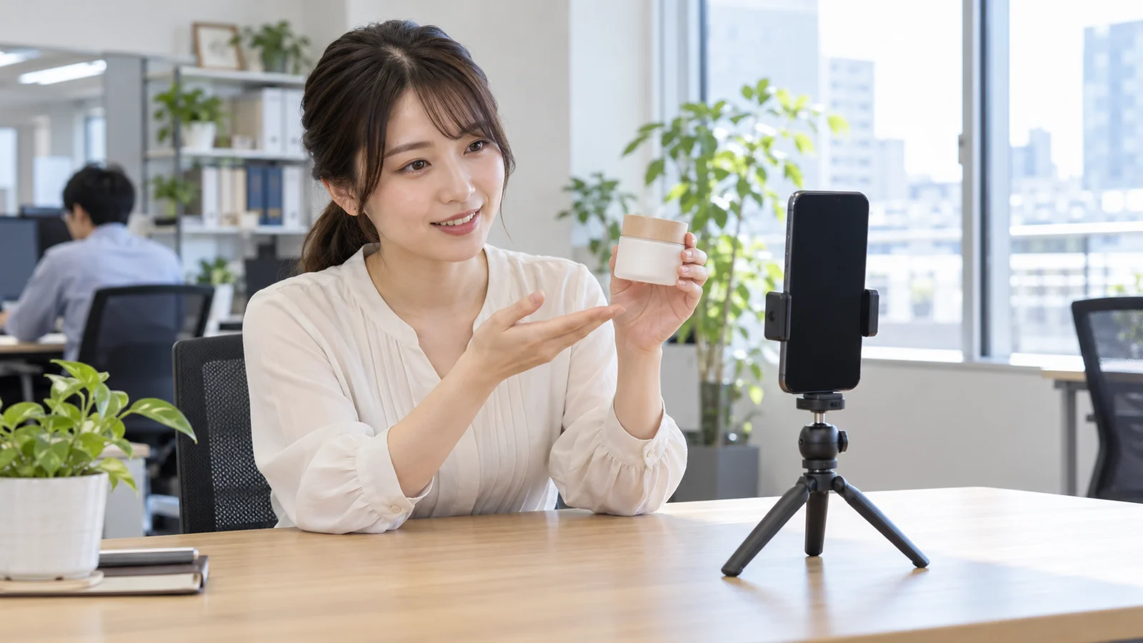 スマートフォンと三脚で短い商品動画を撮影している社員